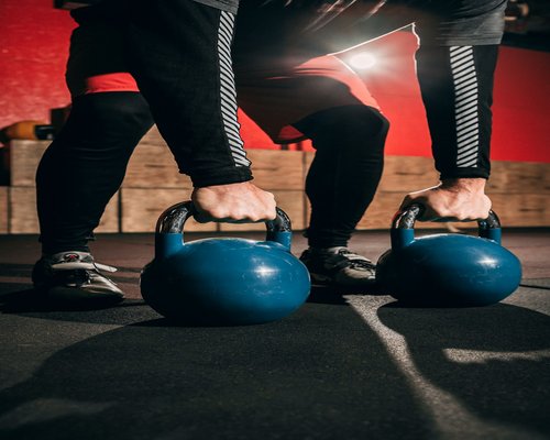 Group of people doing functional exercises with kettlebells